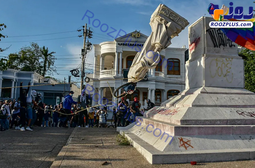 معترضان کلمبیایی در حال پایین کشیدن مجسمه 