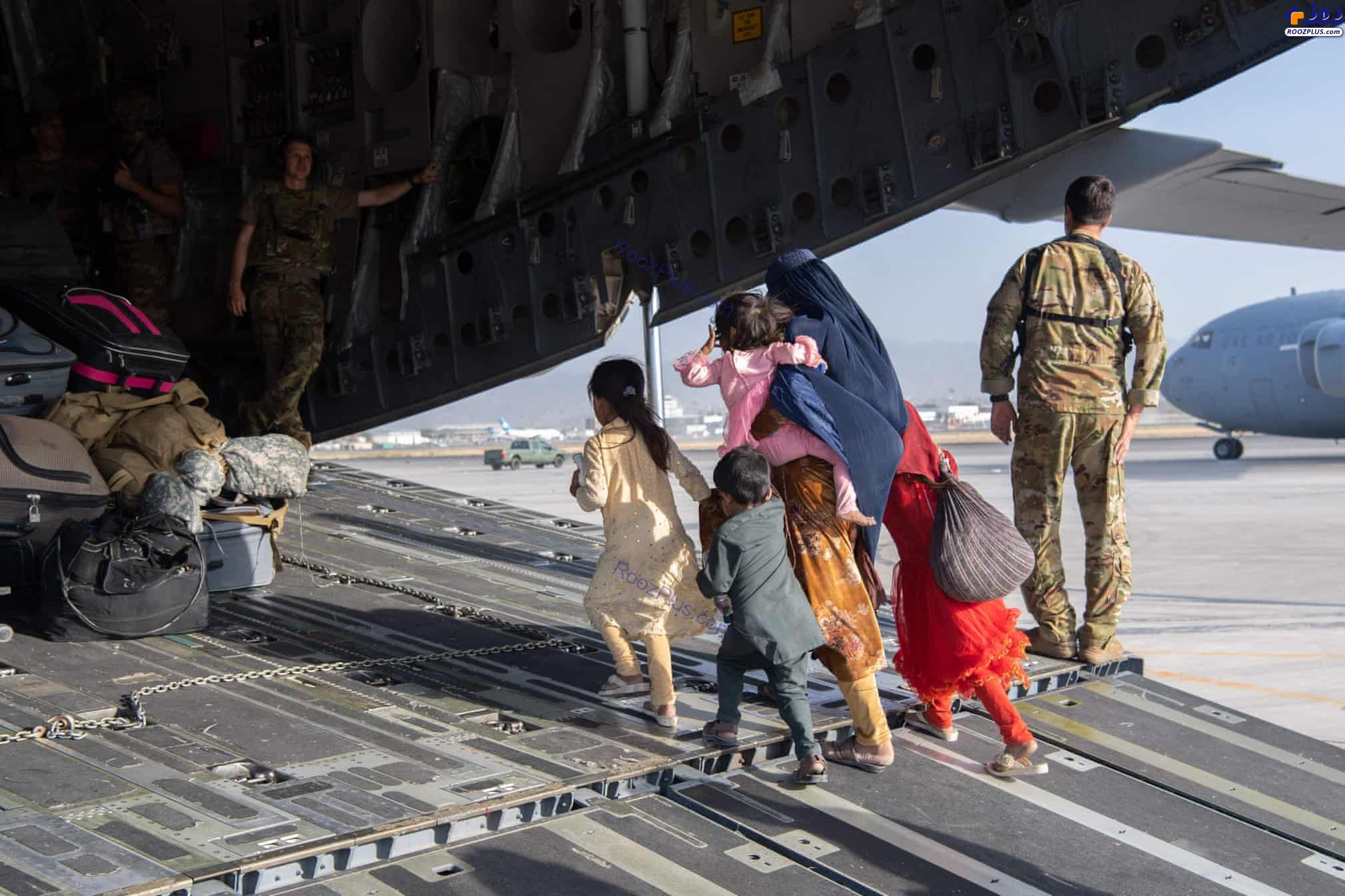 یک خانواده افغان در حال ورود به هواپیمای نظامی آمریکا +عکس